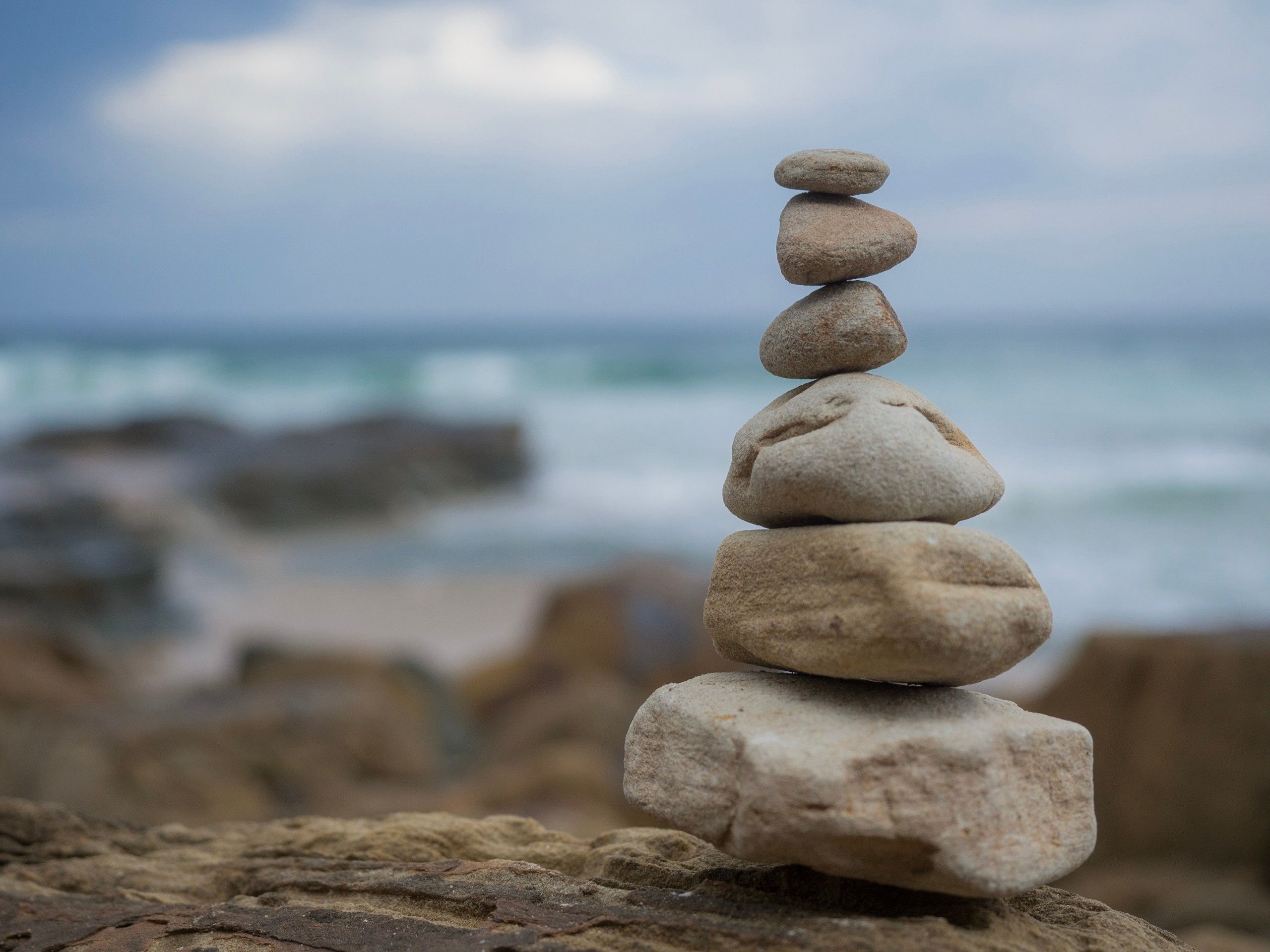 Cairn,Of,Stacked,Rocks,Against,The,Beautiful,Ocean,Background,,Representing